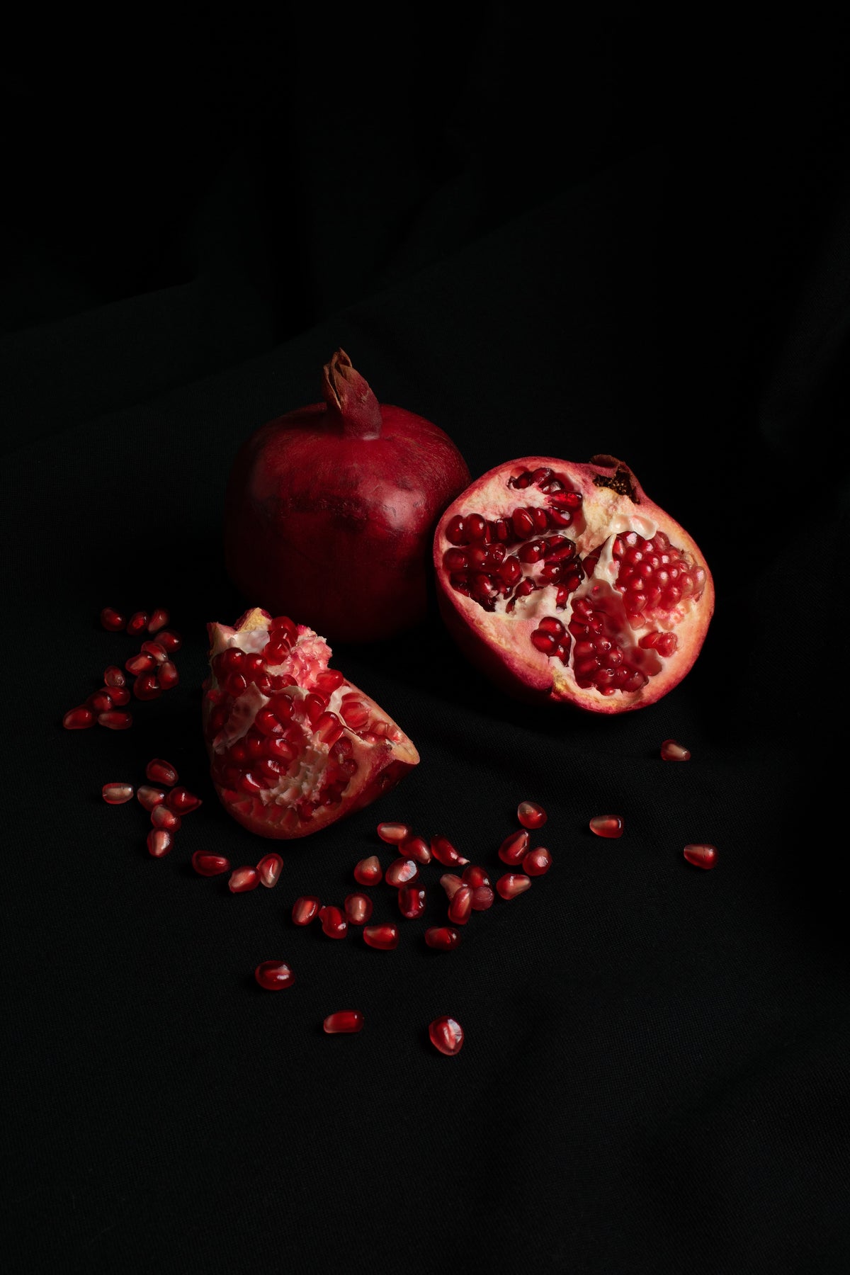 Pomegranate and its seeds on a black background